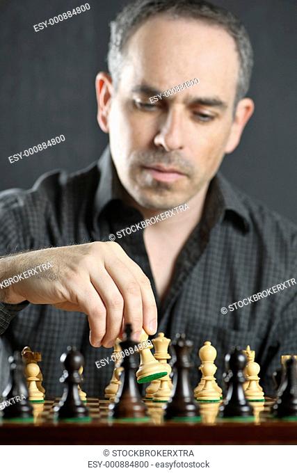 Man moving a chess pawn on wooden chessboard as first move