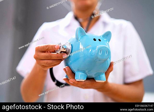 Doctor Health Checking Piggy Bank With Money Inside