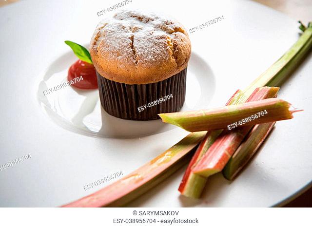 Rhubarb and ginger muffins on white plate
