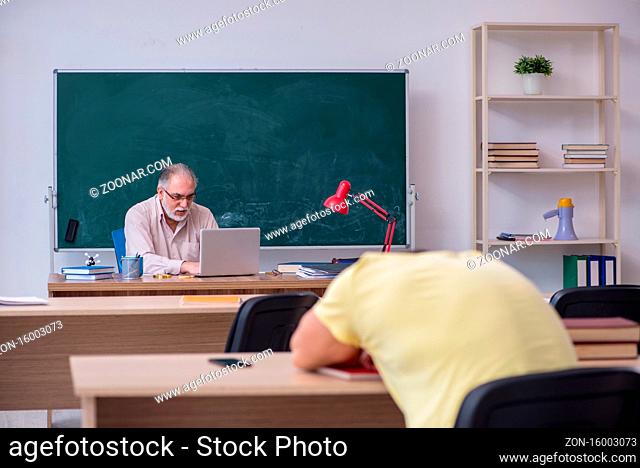 Old teacher and young student in the classroom