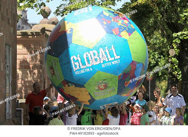 Children carry a big football in front of the Hyatt Regency Hotel in Mainz, Germany, 06 June 2014. Due to the charity campaign 'Globall' fans have the...