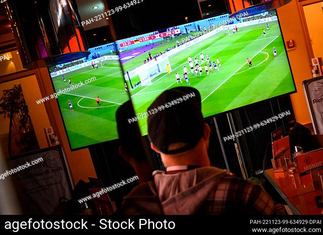 23 November 2022, Hamburg: Soccer: World Cup, Germany - Japan, preliminary round, Group E, Matchday 1, a man sits in a pub in the St