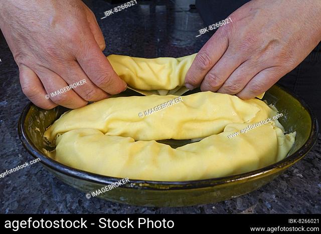 Swabian cuisine, preparing Rutesheim raw strudel, putting filled noodle patties in casserole dish, noodle dough, Rutesheim national dish, poor people's food