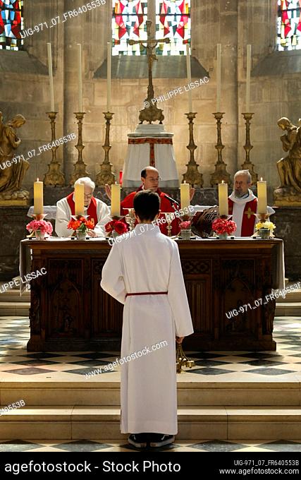Pentecost mass in St Nicolas's church, Beaumont-le-Roger, France. Altar boy
