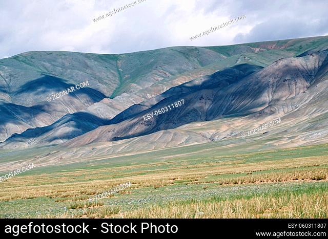Mongolian mountain natural landscape with shadows from clouds near lake Tolbo-Nuur in north Mongolia