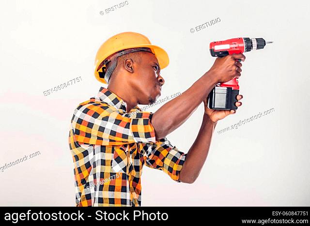 African American construction worker in helmet uses electric screwdriver