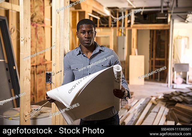 Architect reading blueprints at construction site