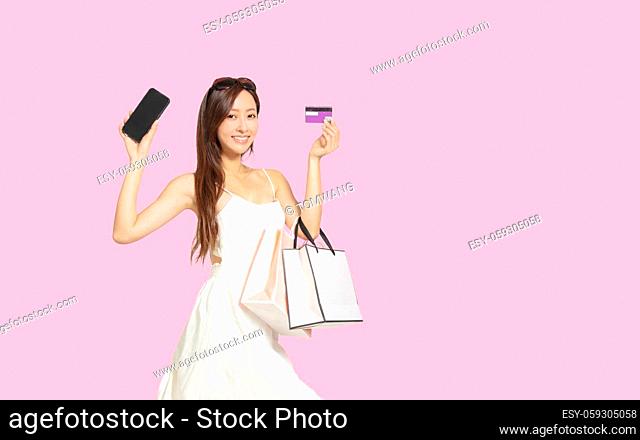 Young woman showing mobile phone and credit card with shopping online concept