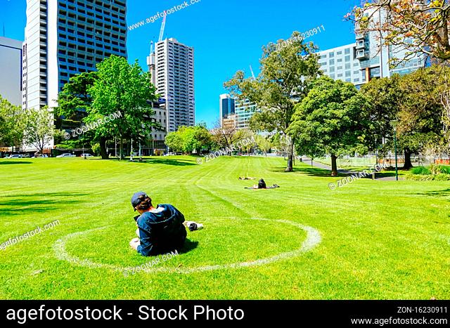 Melbourne, Australia - October 16th 2020: People enjoy the warm spring weather within social distance painted circles in Melbourne parks during the Coronavirus...