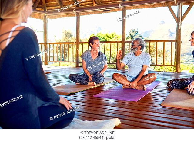 Man and woman talking during yoga class in hut on yoga retreat