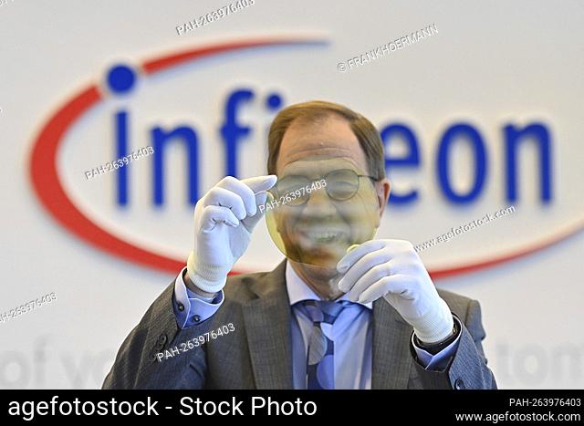 Dr. Reinhard Ploss Chairman of Management (CEO) in front of the logo, holding a transparent wafer (semiconductor), emblem, lettering, single image