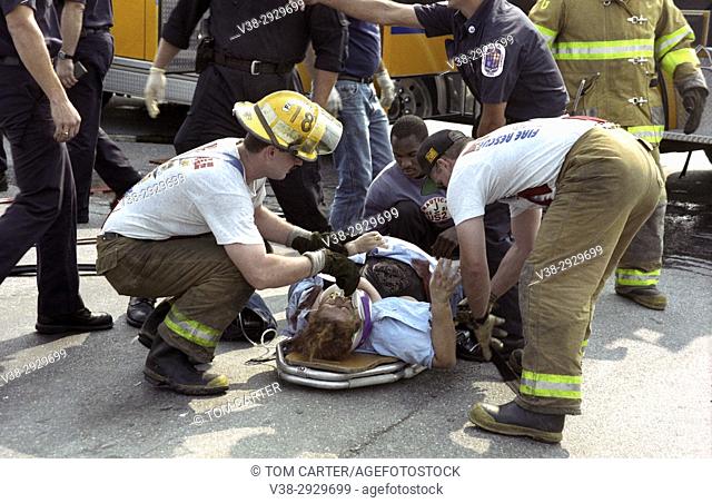 Firefighters work on a woman injured in a car accident in Glendale, Md