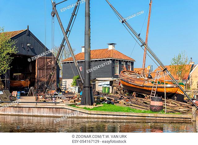 Historical ships at shipyard with slipway in harbor Dutch fishing village Workum