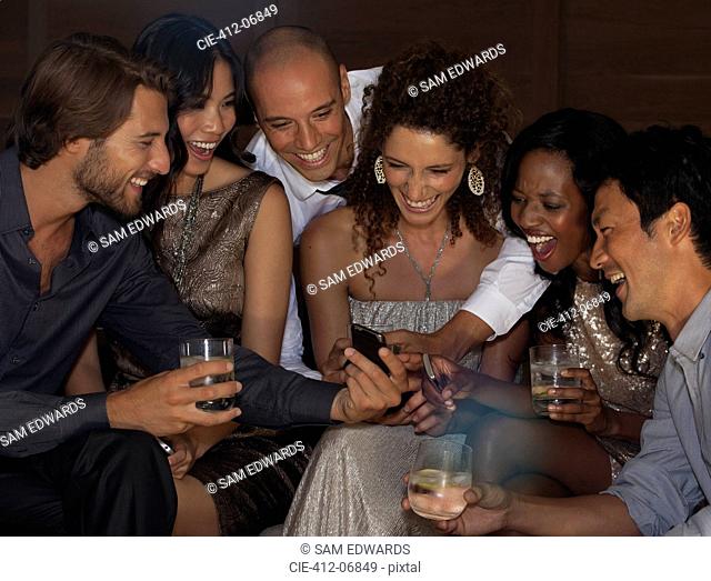 Friends using cell phone at party