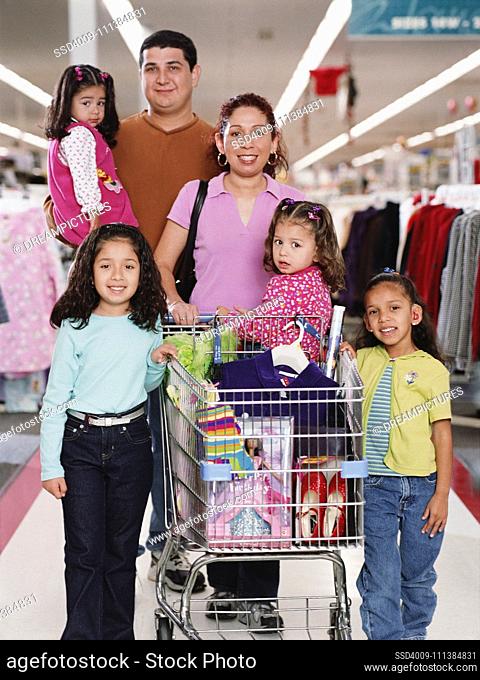 Hispanic family with shopping cart in department store