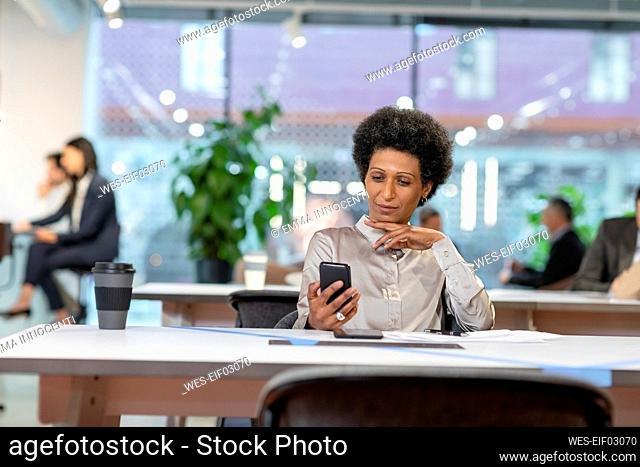 Employee using smart phone in office