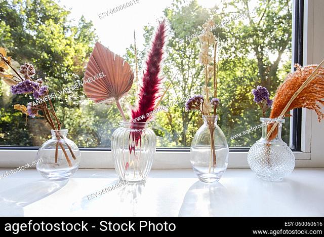 decorative vases and flowers with interior decor concept on window sill, Still life beautiful vase with dried flowers . The concept of comfort and home decor