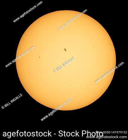 The International Space Station, with a crew of seven aboard, is seen in silhouette as it transits the sun at roughly five miles per second, Friday, April 23