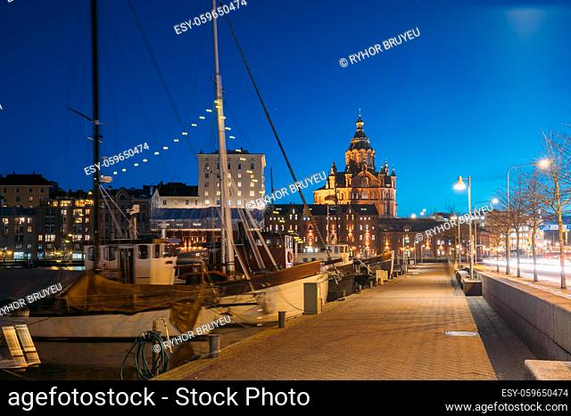 Helsinki, Finland. Pier With Boats, Pohjoisranta Street And View Of Uspenski Cathedral In Evening Night Illuminations