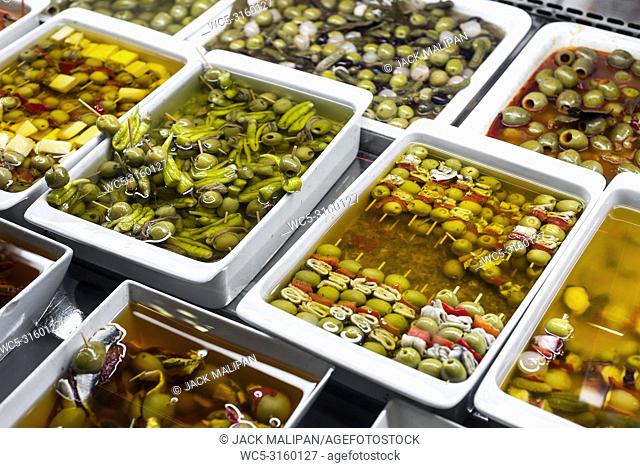 mixed olive tapas snacks in la boqueria market display trays in barcelona spain