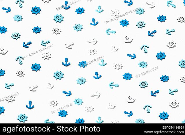 Decorative pattern from ship's marine symbols plastic anchors and steering wheels on a light grey background