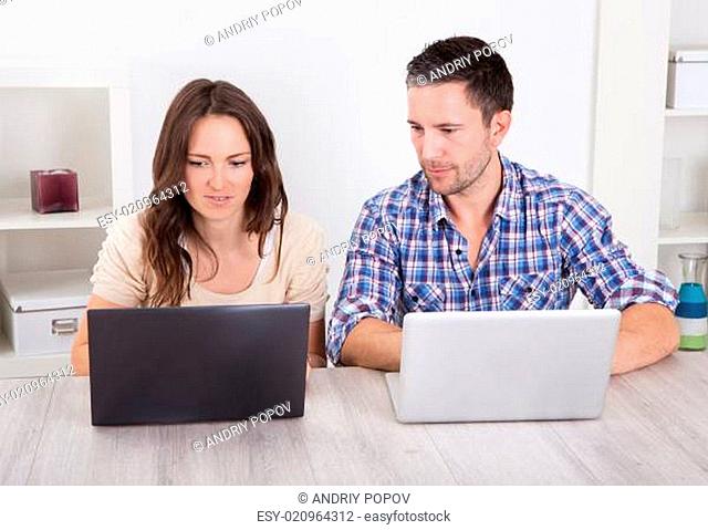 Serious Young Couple Using Laptop