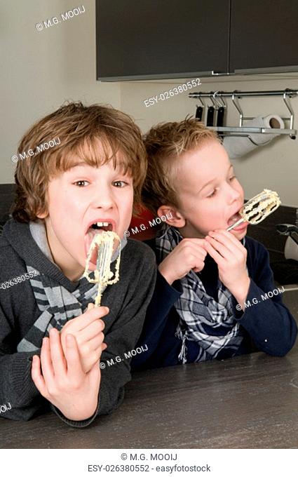 Boys eating the dough that's left behind on the beater