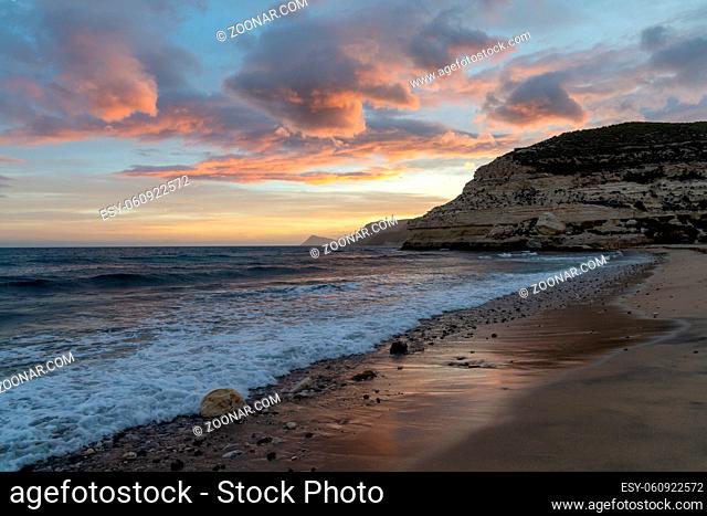 A beautiful ocean sunset on the Costa del Sol in Spain with beach and cliffs in the background