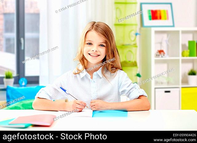 happy smiling school girl with notebook and pen