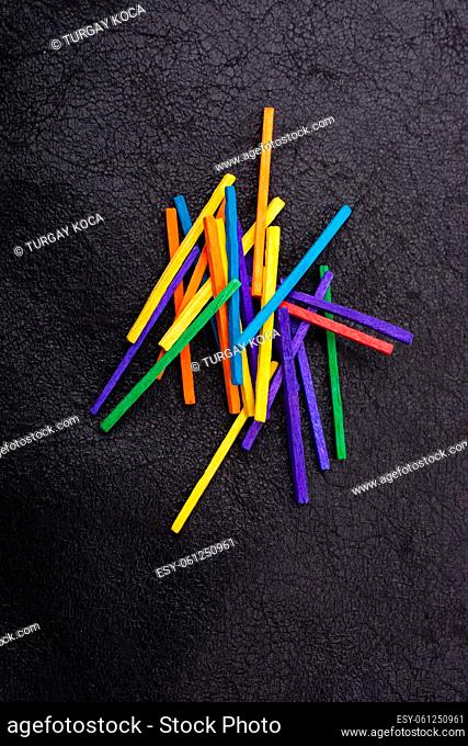 Beautiful coloured wooden sticks for creativity on black background