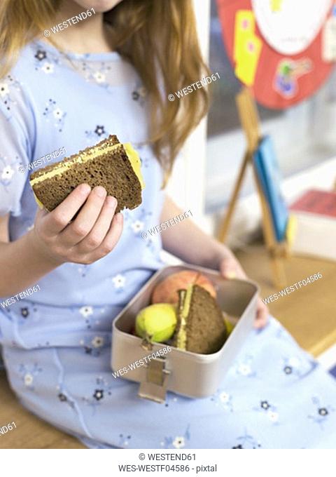 Girl holding lunch box, close-up