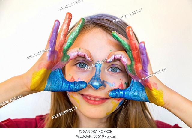 Portrait of smiling girl with finger paints on hands