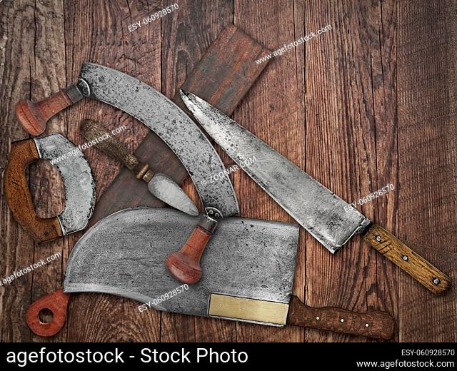 faded colors if a vintage kitchen knives and sharpening tools collage over old wooden table, space for your text