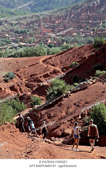 HIKING ON THE RED EARTH HILLS OF THE DJEBEL KLELOUT NEAR THE BERBER VILLAGE OF OUTGHAL, AL HAOUZ, MOROCCO