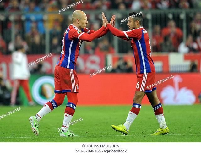 Bayern Munich's   Arjen Robben (l) and Thiago clpa hands during the DFB Cup semi final soccer match between FC Bayern Munich and Borussia Dortmund at Allianz...