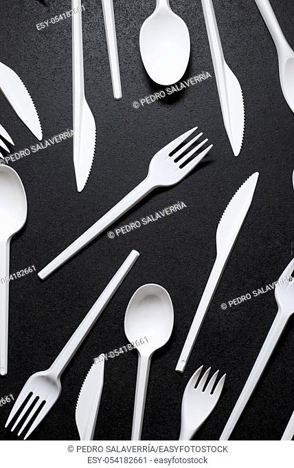 Disposable plastic cutlery on a black table