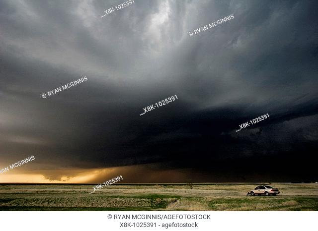 A storm chaser's car is parked as a storm chaser watched a lowering wall cloud a precursor to a tornado near Hill City, Kansas, USA, 4/24/2008
