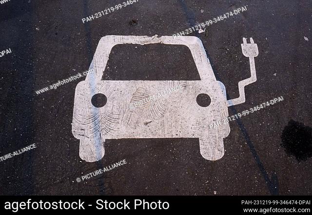 19 December 2023, Lower Saxony, Hanover: A symbol on a parking lot marks a charging facility for electric cars. After the sudden end of the purchase premium for...