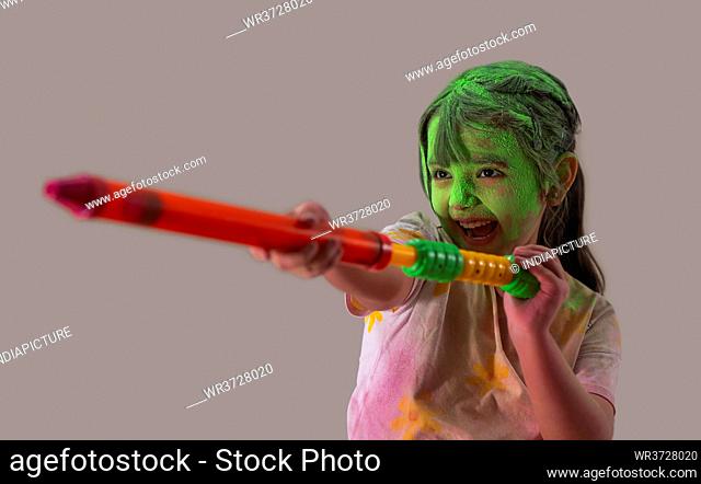 Young girl playing with a pichkari on holi