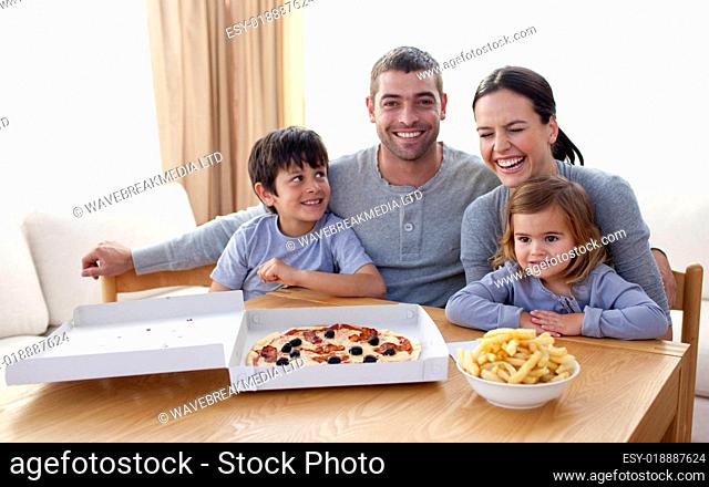 Family eating pizza and fries on a sofa