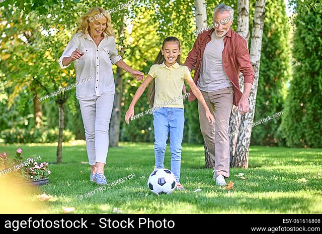 Football. Happy family playing football in the park