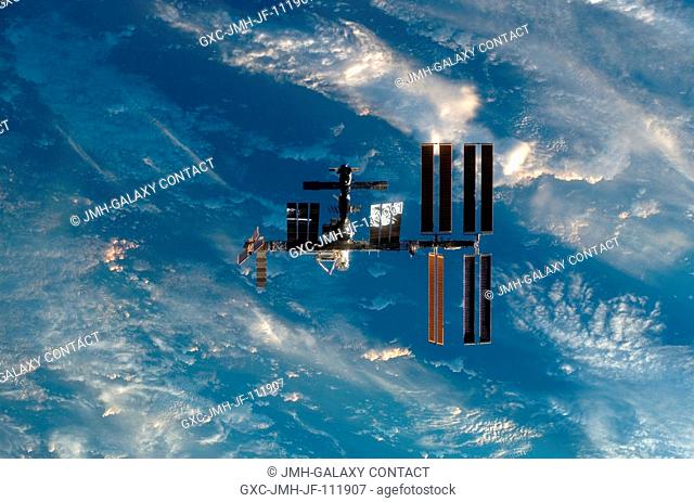 Backdropped by a blue and white part of Earth, the International Space Station is seen from Space Shuttle Endeavour as the two spacecraft begin their relative...