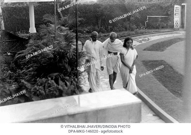 Mahatma Gandhi walking with R.D. Birla and Sushila Nayar at Birla House ; Mumbai ; 1945 ; India NO MR