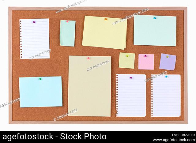 Paper reminder notices on a cork notice board on white background with clipping path