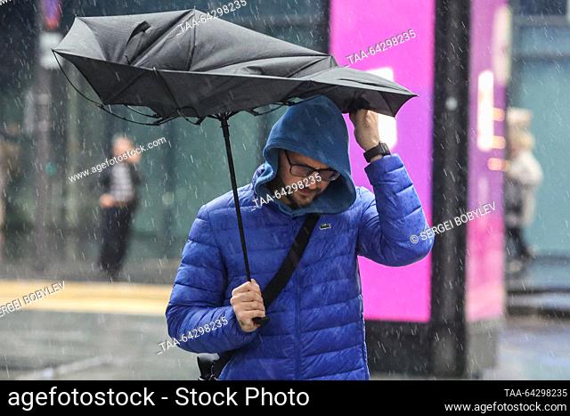 RUSSIA, MOSCOW - NOVEMBER 2, 2023: A man holding an umbrella struggles with the wind while walking in the rain in late autumn. Sergei Bobylev/TASS