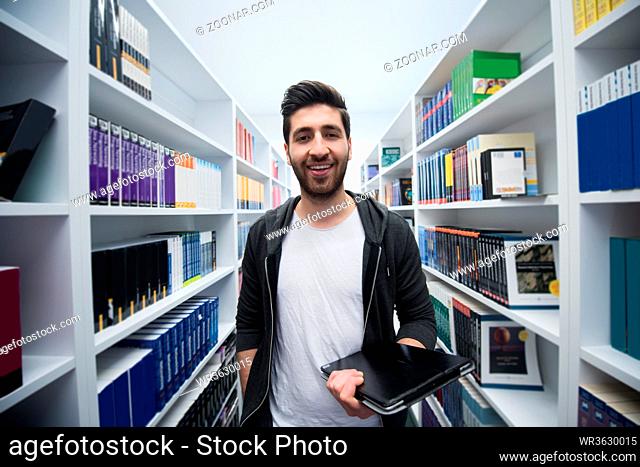 portrait of student in school library with tablet computer. Database and archive management business concept