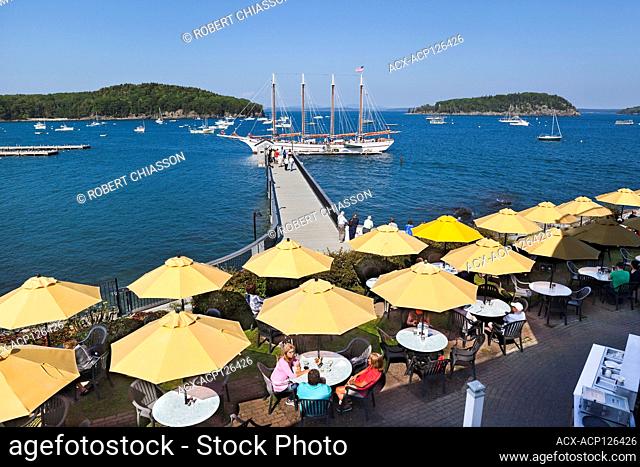 Bar Harbor Inn's Terrace Grille (in the foreground) and pier at the end of which is the Margeret Todd Schooner, Frenchman's Bay, Bar Harbor, Maine, USA