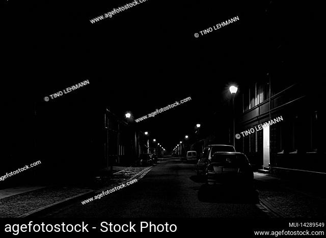 Well-lit side street at night in the small town of Luckenwalde, black and white