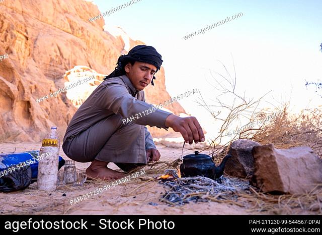 26 November 2021, Jordan, Wadi Rum: A Bedouin prepares tea in a kettle on a campfire in the Wadi Rum desert. Photo: Sebastian Kahnert/dpa-Zentralbild/dpa