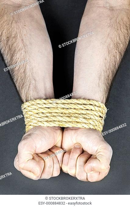 Male hands tied up with strong rope